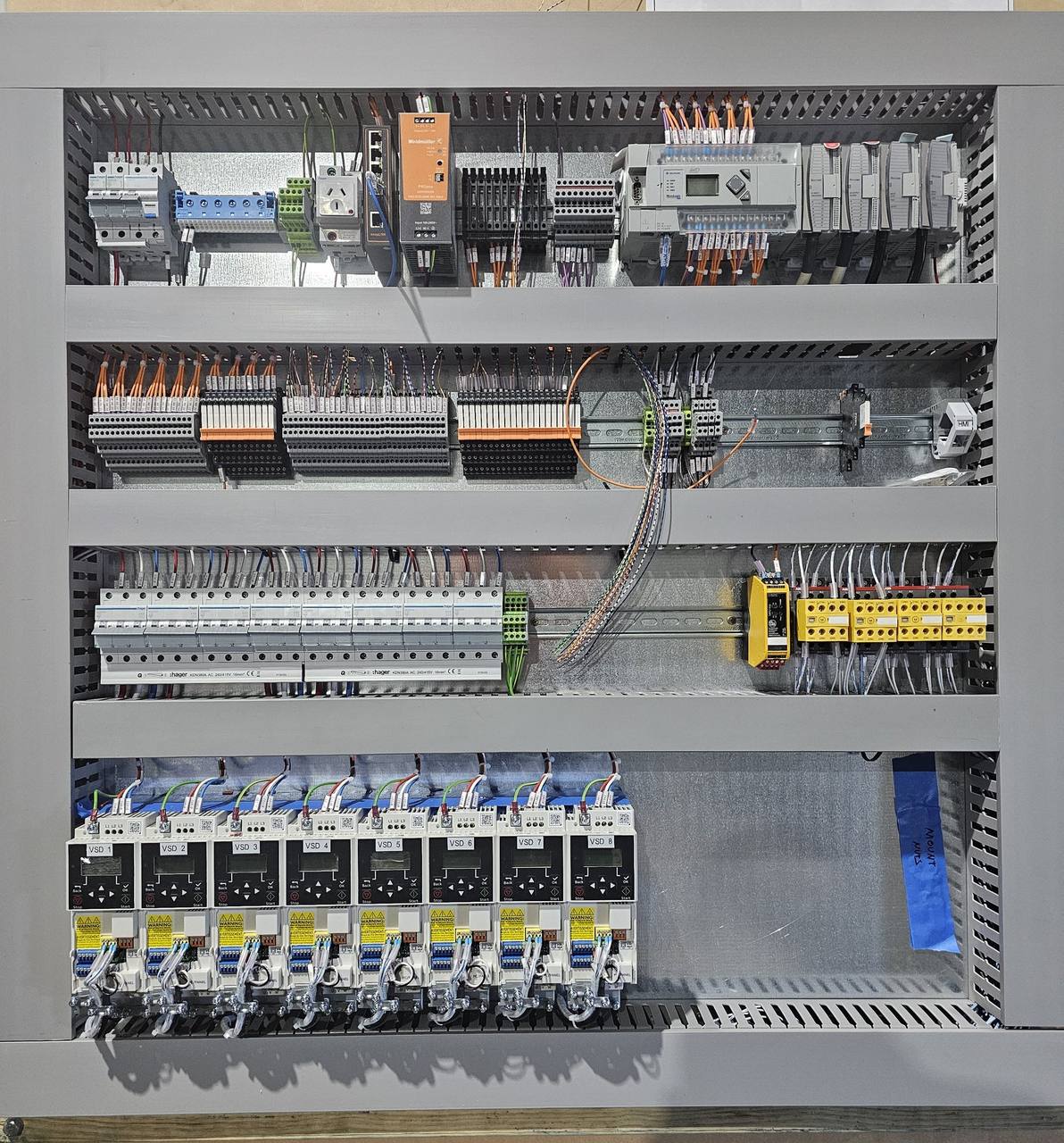 Finished conveyor control panel with duct lids fitted, PLC, safety relays and eight variable speed drives