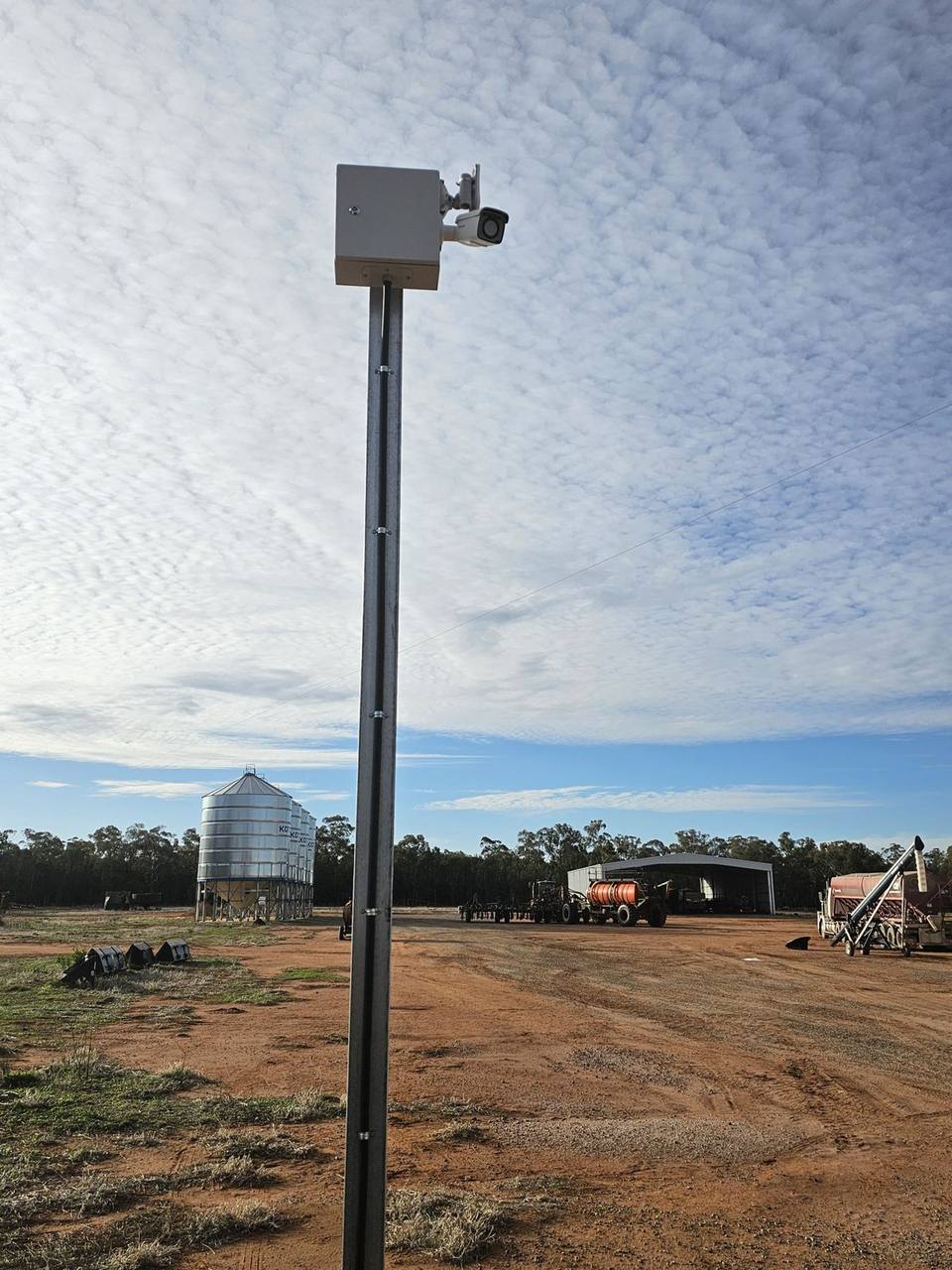 Farm CCTV pole beside sheds and silos